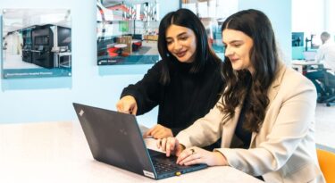 two people working together while viewing at laptop at Wates