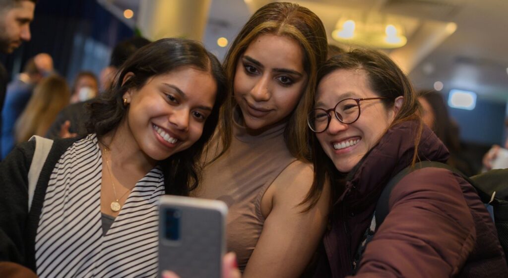women posing for a selfie at promoted trainees event